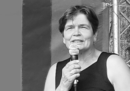 Cornelia Sperling mit Mikrofon auf einer Bühne